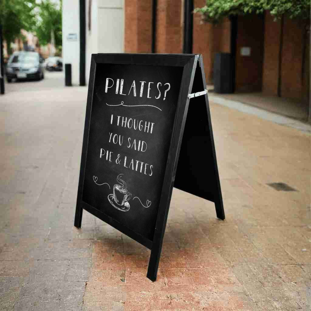 This black wooden A-board pavement sign features a durable chalkboard surface, ideal for handwritten messages, menus, and special offers.