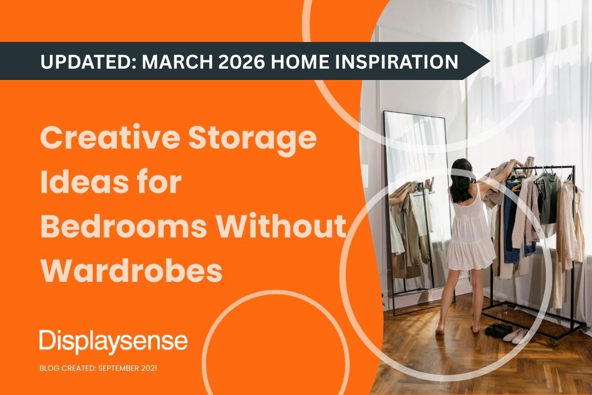 A woman in a white dress browses garments on a black commercial clothes rail next to a floor-length mirror in a bright bedroom with parquet flooring — featured image for the Displaysense guide to creative storage ideas for bedrooms without wardrobes