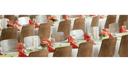 Neatly arranged banquet tables set with glassware, menus, red napkins, and floral centerpieces—ideal for catering, hospitality, and large-scale event service sectors.