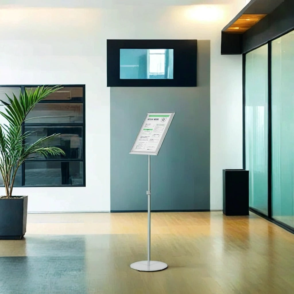  A versatile A3 freestanding poster display stand with an adjustable telescopic pole, allowing height adjustments from 968mm to 1428mm. Features a snap frame for quick literature changes, which can be positioned in portrait or landscape. Includes a round weighted base for stability, making it ideal for exhibitions, retail spaces, and hospitality venues.