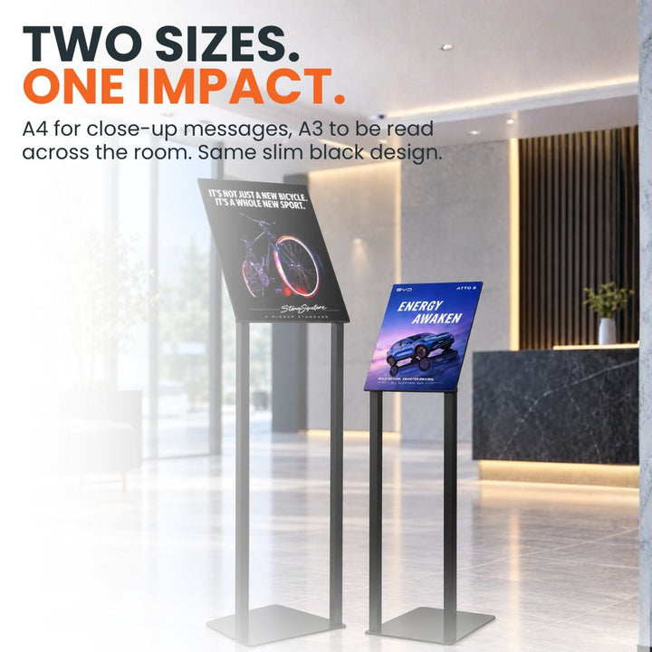 A4 and A3 black freestanding poster stands displayed together in a reception area to compare the two available poster sizes.