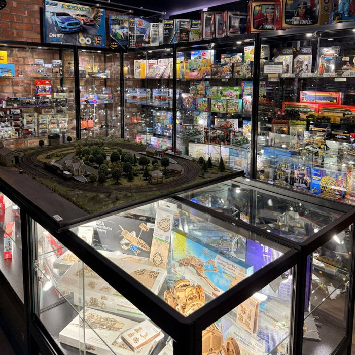 Black glass collectables display cabinets with a model railway layout