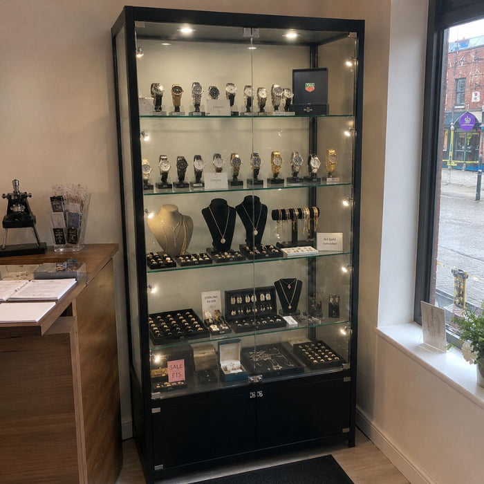 Black illuminated jewellery and watch display cabinet positioned beside a shop window for a luxury retail display