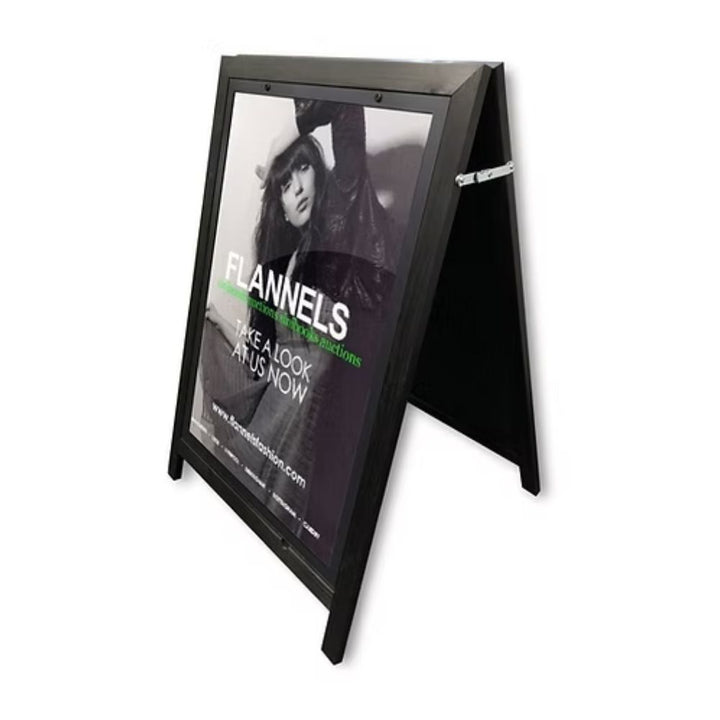 Black rubberwood A1 A-board pavement sign in a three-quarter cut-out view, showing the matte black timber frame, wide-leg stance and top hinge brace.
