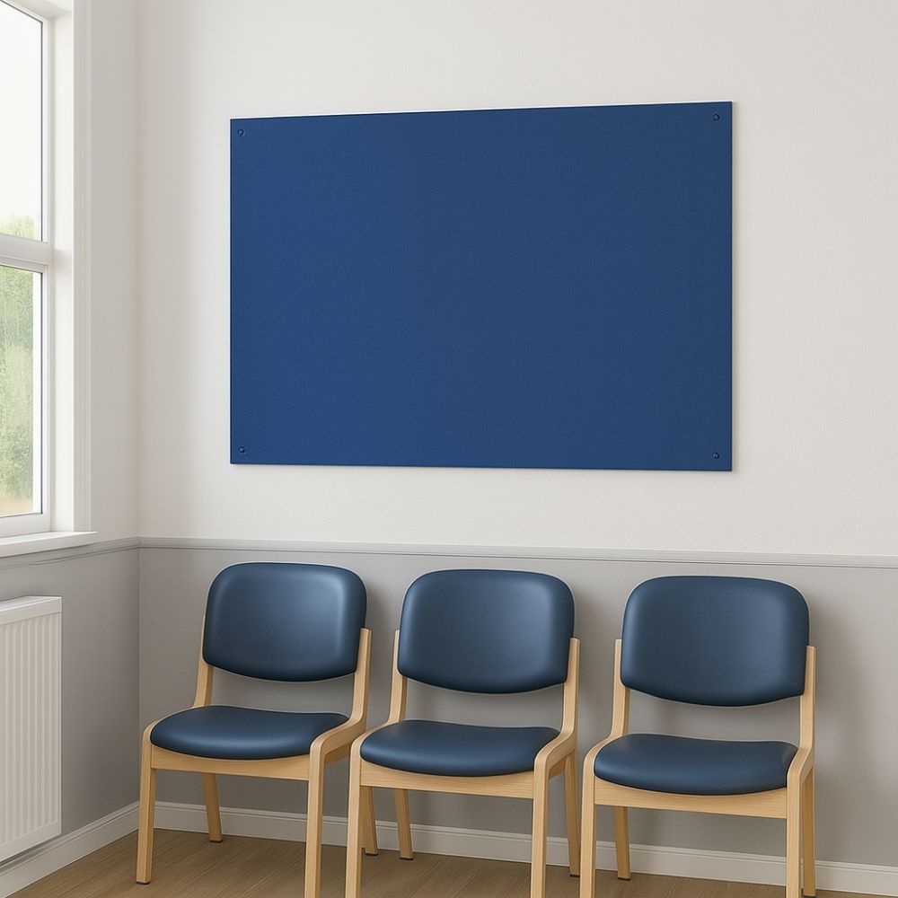 Blue fabric pinboard mounted on a white wall above a row of three wooden-framed chairs with navy blue seats and backs in a well-lit waiting room.