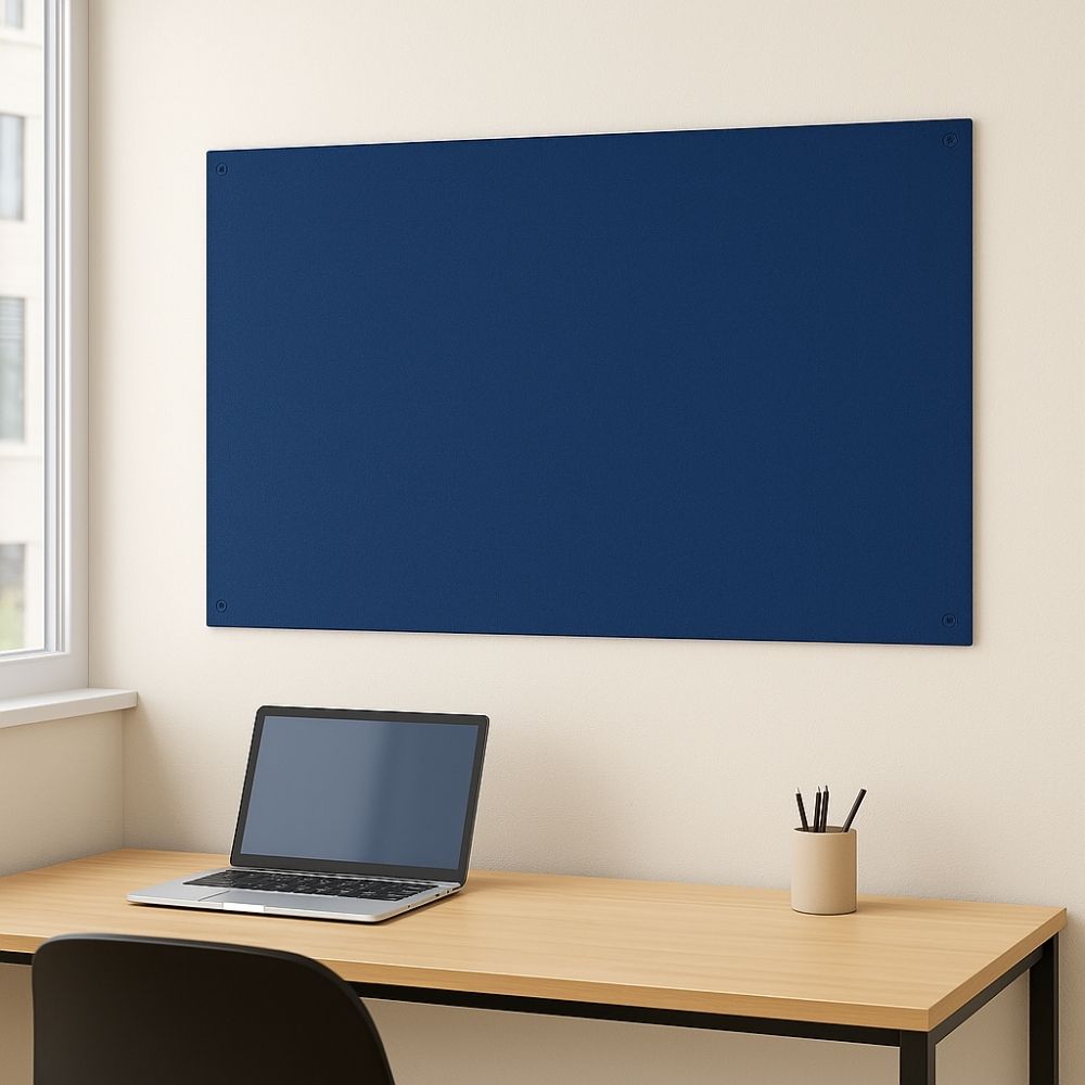 Dark blue fabric pinboard mounted on a cream wall above a light wooden desk with a laptop, pencil pot, and window in a tidy home office setting.