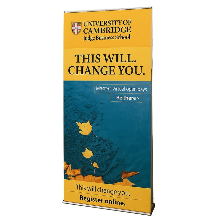Close-up of a Cambridge Judge Business School promotional roller banner with bold academic messaging and blue and yellow design for student recruitment events.

