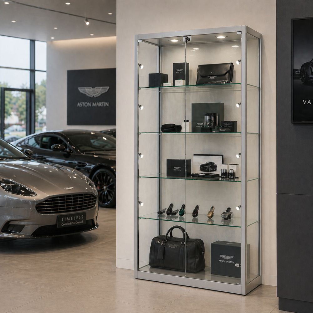 Silver glass display cabinet with LED lighting displaying branded accessories