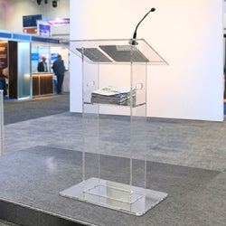 transparent-acrylic-lectern-with-mounted-microphone-and-documents-on-shelf-in-modern-exhibition-or-conference-setting