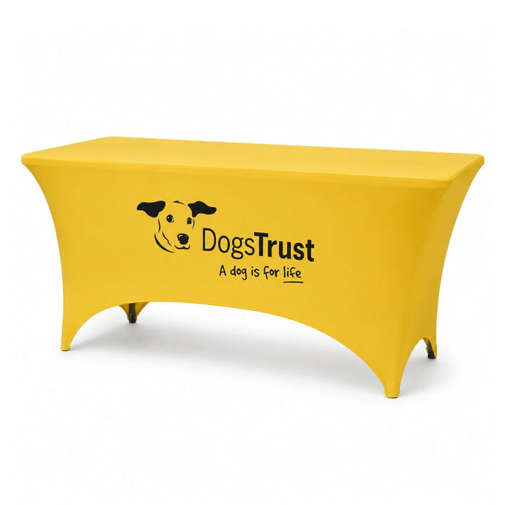 Yellow fitted stretch tablecloth with Dogs Trust printed branding displayed on a plain white background.