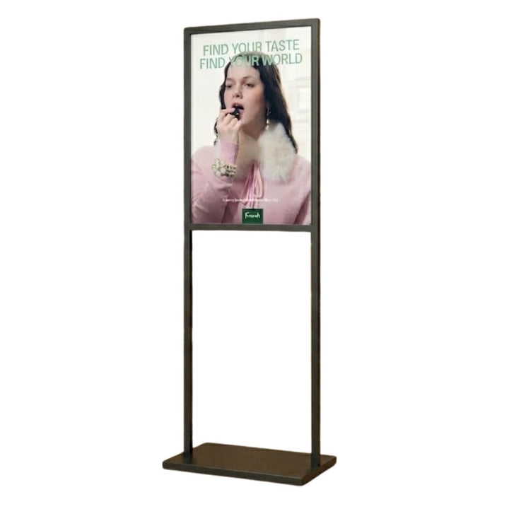 Side-on, the upright steel frame sits on a solid rectangular base, the A1 panel held in the upper section above an open lower span, ready for foyer use.
