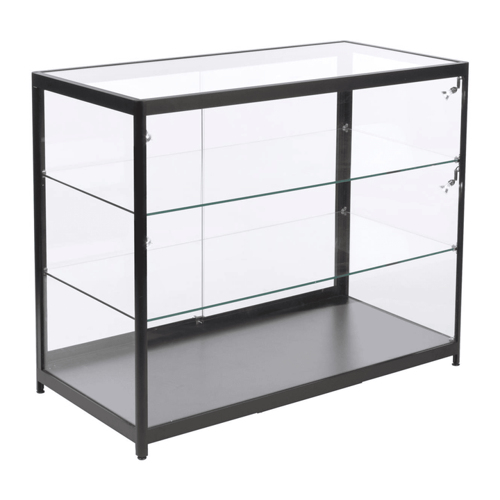 Shown against white, the counter cabinet is glazed on top and all four sides, two glass shelves stacked above a solid base deck for point-of-sale display.
