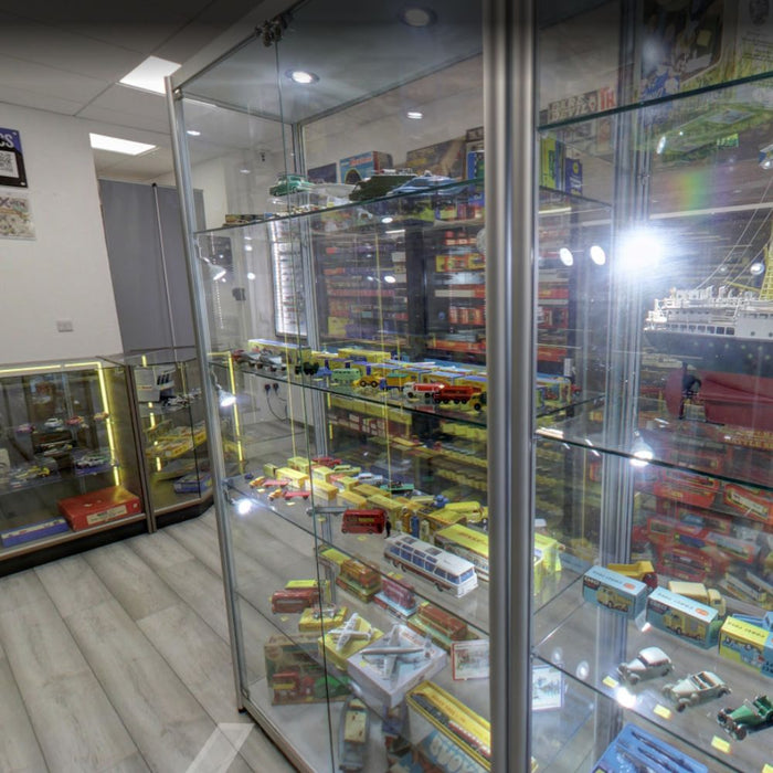 Glass model vehicle display cabinet with vintage toy cars and buses