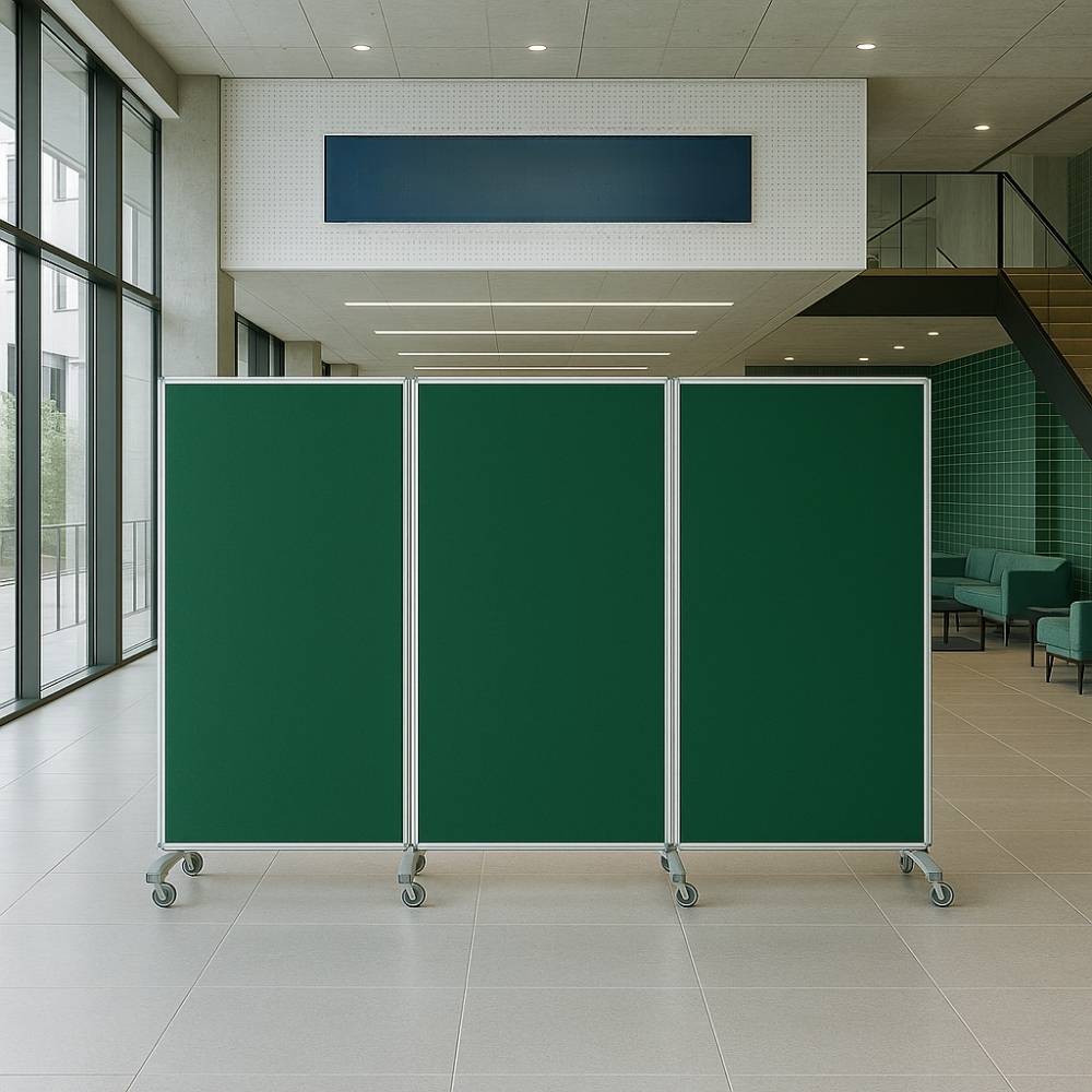 Mobile green felt three-panel room divider with metal frame positioned in a contemporary school foyer with tiled floors and green seating area.