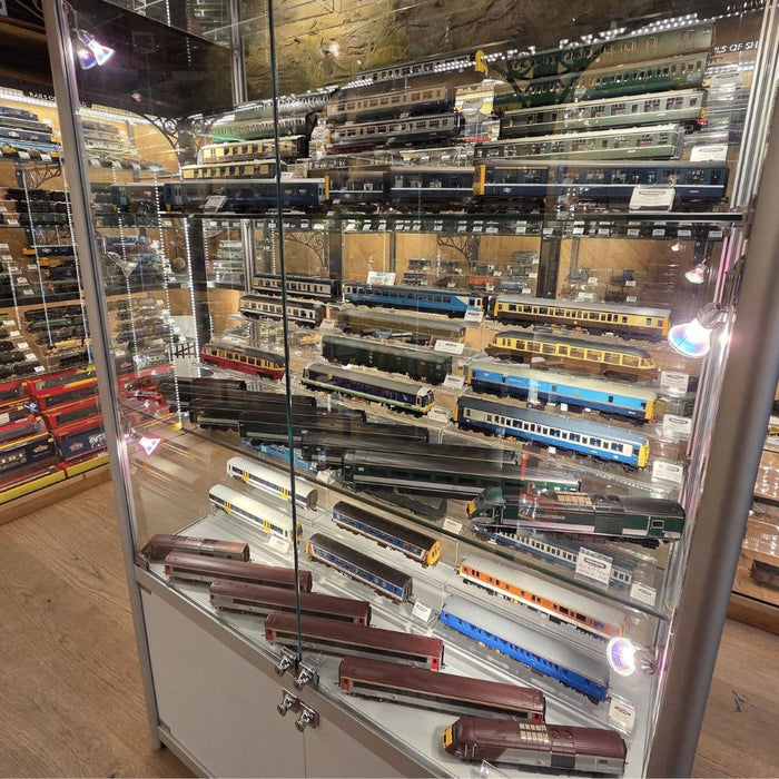 Illuminated glass model train display cabinet in a railway shop