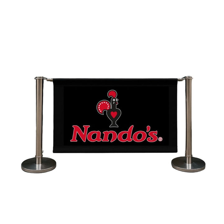 Studio product image of a Nando’s branded café barrier featuring black banner and polished chrome posts—designed for restaurants, takeaways, and hospitality venues.


