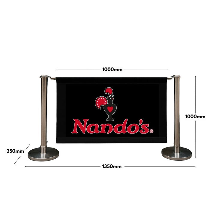 Nando’s branded café barrier with black canvas panel and chrome stanchions—dimensions: 1350mm width, 1000mm height, and 1000mm banner span—ideal for outdoor dining spaces.

