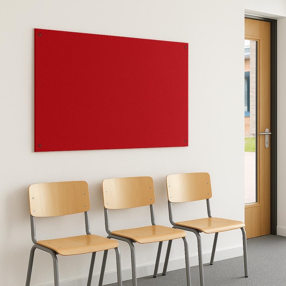 Red fabric noticeboard mounted on a white wall above three wooden chairs with grey metal legs in a school hallway near a wooden-framed glass door.