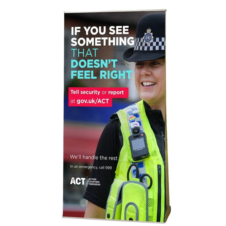 Roll up banner featuring a security awareness message with a smiling police officer, used for counter-terrorism campaigns in public venues.