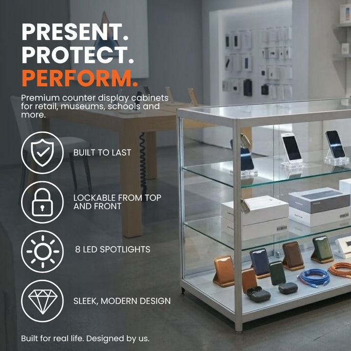 Silver aluminium glass counter display cabinet in a retail setting, highlighting lockable access, eight LED spotlights, durable construction and a sleek modern design.