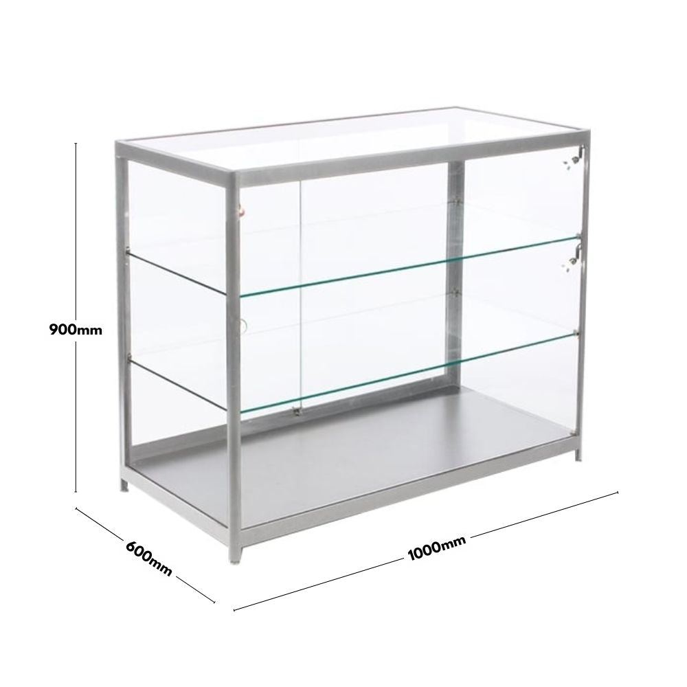  A silver aluminium glass counter display cabinet with dimensions of 1000mm in width, 600mm in depth, and 900mm in height. The cabinet features a sturdy aluminium frame with tempered glass panels and two glass shelves for secure and stylish product display. It includes lockable sliding doors for added security, making it ideal for retail and exhibition use