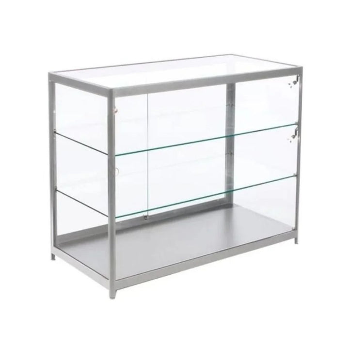 Empty silver aluminium glass counter display cabinet with two glass shelves and a solid base panel, three-quarter view on a white background.
