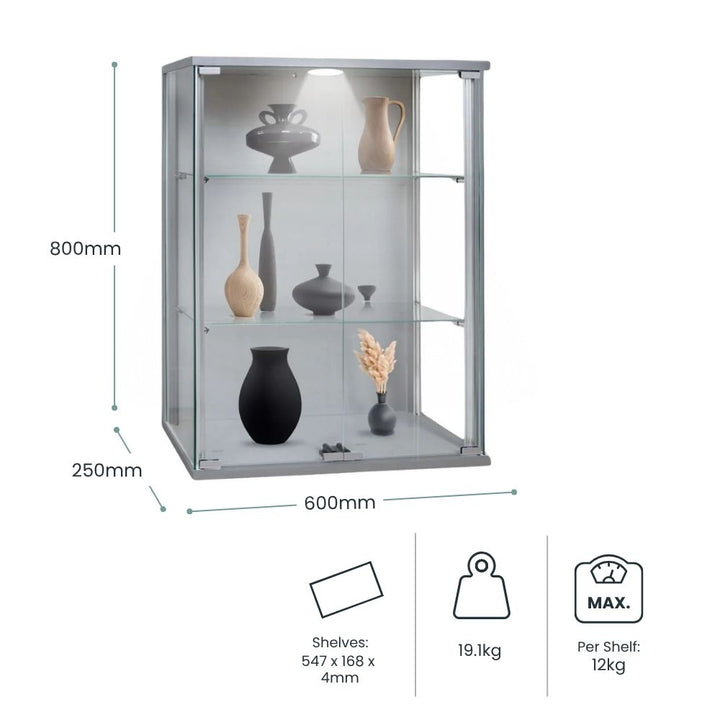 Dimension diagram of a silver wall mounted display cabinet, 600mm wide by 800mm high, with two glass shelves displaying ceramics and decorative homeware.
