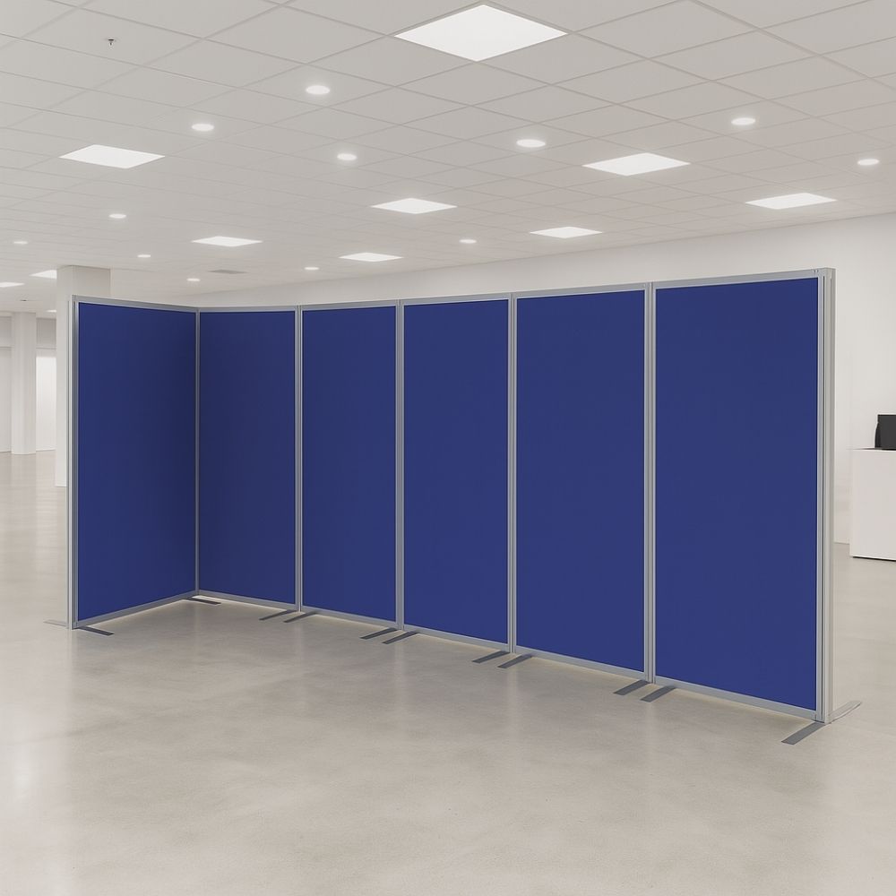 Six-panel blue fabric room divider with silver aluminium frame and stabilising flat feet, arranged in a zigzag formation within a spacious modern office environment.