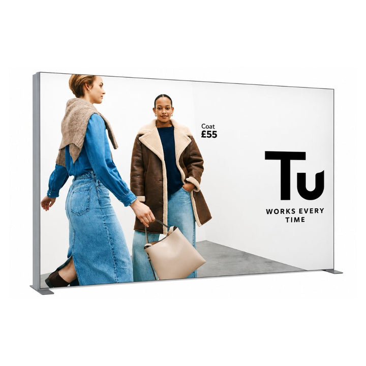 Wide retail fabric display wall featuring Tu clothing campaign with fashion models, denim outfits and winter coat promotion.