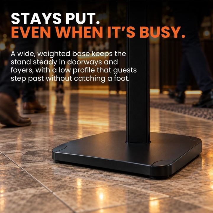 Wide low-profile weighted base on the black floor standing poster stand, designed to keep the display steady in busy entrances and foyers.