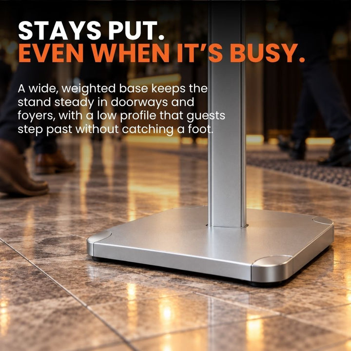 Low-profile weighted base and central silver upright shown at floor level on the A4 freestanding poster stand.