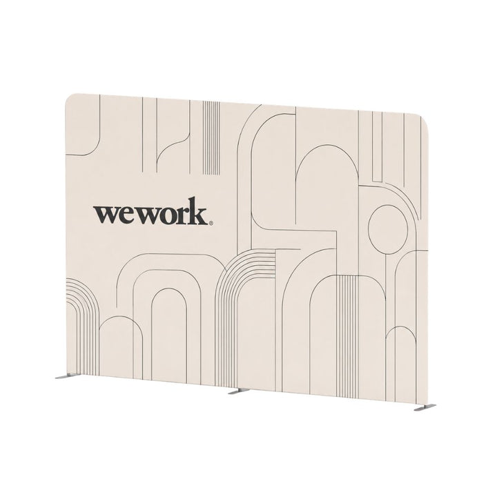 Freestanding WeWork branded exhibition backdrop display with minimalist geometric graphics and seamless curved panel design.
