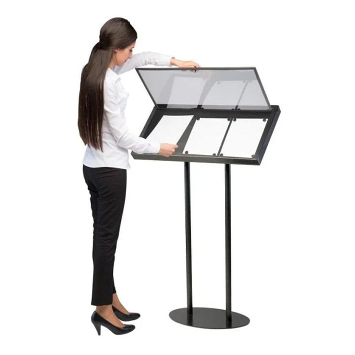 Staff member lifting the magnetic anti-glare cover of a 3 x A4 floor-standing menu board to change a printed menu poster, shown on white.
